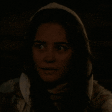 a woman with a hood on her head looks at another woman