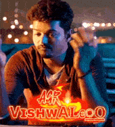 a man sitting in front of a sign that says agr vishwaleo