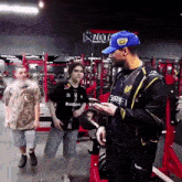 a man in a blue hat is talking to a boy in a black shirt that says betboo on it