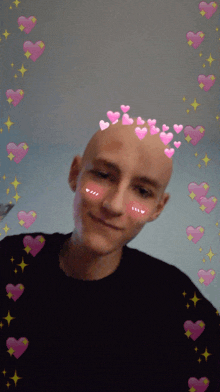 a bald man with pink hearts on his head is smiling
