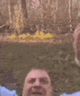 a man wearing a yellow vest and tie is screaming with his mouth wide open .