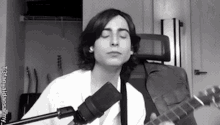 a man is singing into a microphone while playing a guitar .