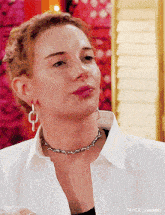 a close up of a woman wearing a white shirt and a choker necklace