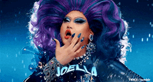 a drag queen with purple and blue hair and the name joella