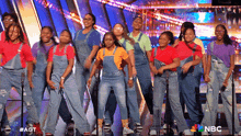 a group of young girls are dancing on a stage in front of a nbc sign