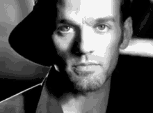 a black and white photo of a man wearing a cowboy hat .