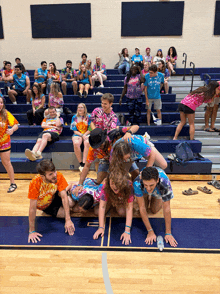 a group of people wearing tie dye shirts are playing a game