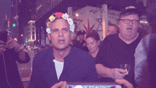a man wearing a hat that says no supply stands in a crowd