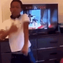 a boy is dancing in front of a tv that says girl code on it