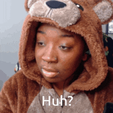 a woman is wearing a teddy bear hooded jacket and says huh