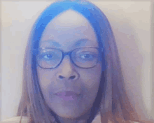 a woman wearing glasses is looking at the camera with a blue background behind her .