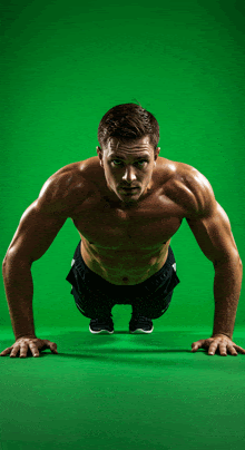 a man doing push ups on a green background