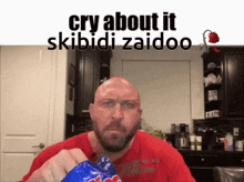 a bald man in a red shirt is holding a bag of m & m 's