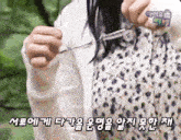 a woman in a floral dress is holding a pair of scissors in her hand .