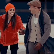 a man and a woman are holding hands while walking on the ice