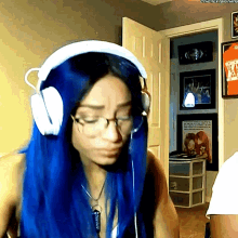 a woman with blue hair is wearing headphones and a necklace