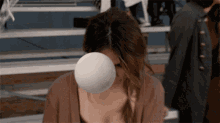a woman blowing a bubble of chewing gum on her face