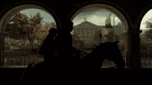 a couple riding a horse in front of a building