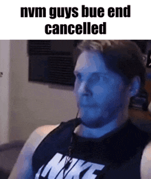 a man wearing a nike shirt is sitting in front of a blue screen