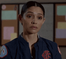 a woman wearing a blue jacket with the letter c on it .