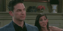 a man in a suit and a woman in a dress are standing next to each other