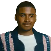a man wearing a blue and pink striped jacket smiles for the camera