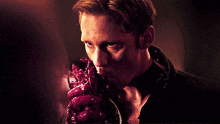 a man holds a bloody heart in his hand