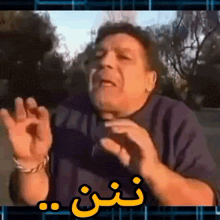 a man in a blue shirt is making a funny face with his hands in the air .
