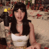 a woman with a tattoo on her arm wearing a white tank top that says supreme