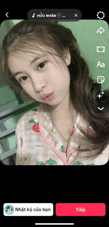 a screenshot of a girl 's face with a strawberry shirt on