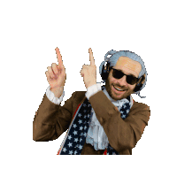 a man wearing sunglasses and an american flag scarf points upwards