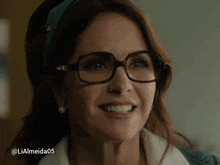 a woman wearing glasses and a headband is smiling with the hashtag lialmeida05 below her