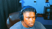 a man wearing headphones is sitting in a chair in front of a computer .