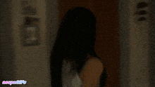 a gif of a woman standing in a dark room with the words vespagifs on the bottom right