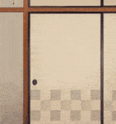 a man in a white shirt and purple tie is standing in front of a checkered door .