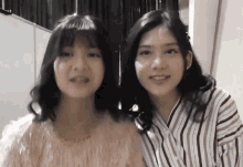 two girls are standing next to each other and smiling