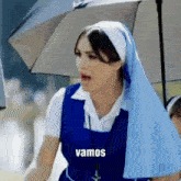 a nun holding an umbrella with the word vamos on the bottom