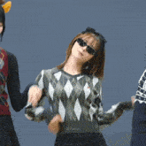 a woman wearing sunglasses and a sweater that says no way on the back