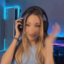 a woman wearing headphones is making a funny face while playing a video game .