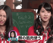 two girls are crying in front of a blackboard that says exit on it