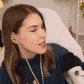 a woman wearing headphones and a microphone is singing into a microphone .