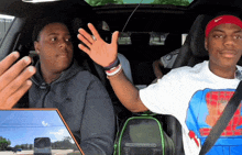 a man wearing a nike shirt is sitting in a car with another man
