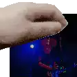 a close up of a person 's hand holding a picture of a man in a red shirt .