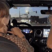 a person driving a car with a dashboard that says ' a ' on it