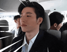 a man in a suit is sitting in a car