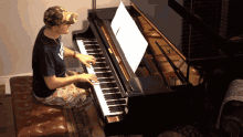 a man is playing a piano with a sheet of music on the shelf