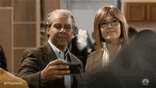 a man and a woman are taking a selfie with their cell phone .