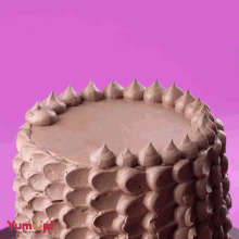 a chocolate cake with a pink background and the word yum on it