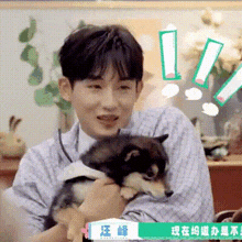 a man is holding a small dog in his arms and making a funny face .