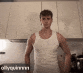 a man in a white tank top is standing in a kitchen with the name ollyquinnn on the bottom